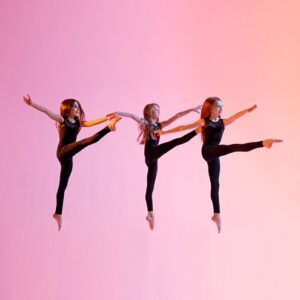 Three contemporary dance students dancing and jumping in the air