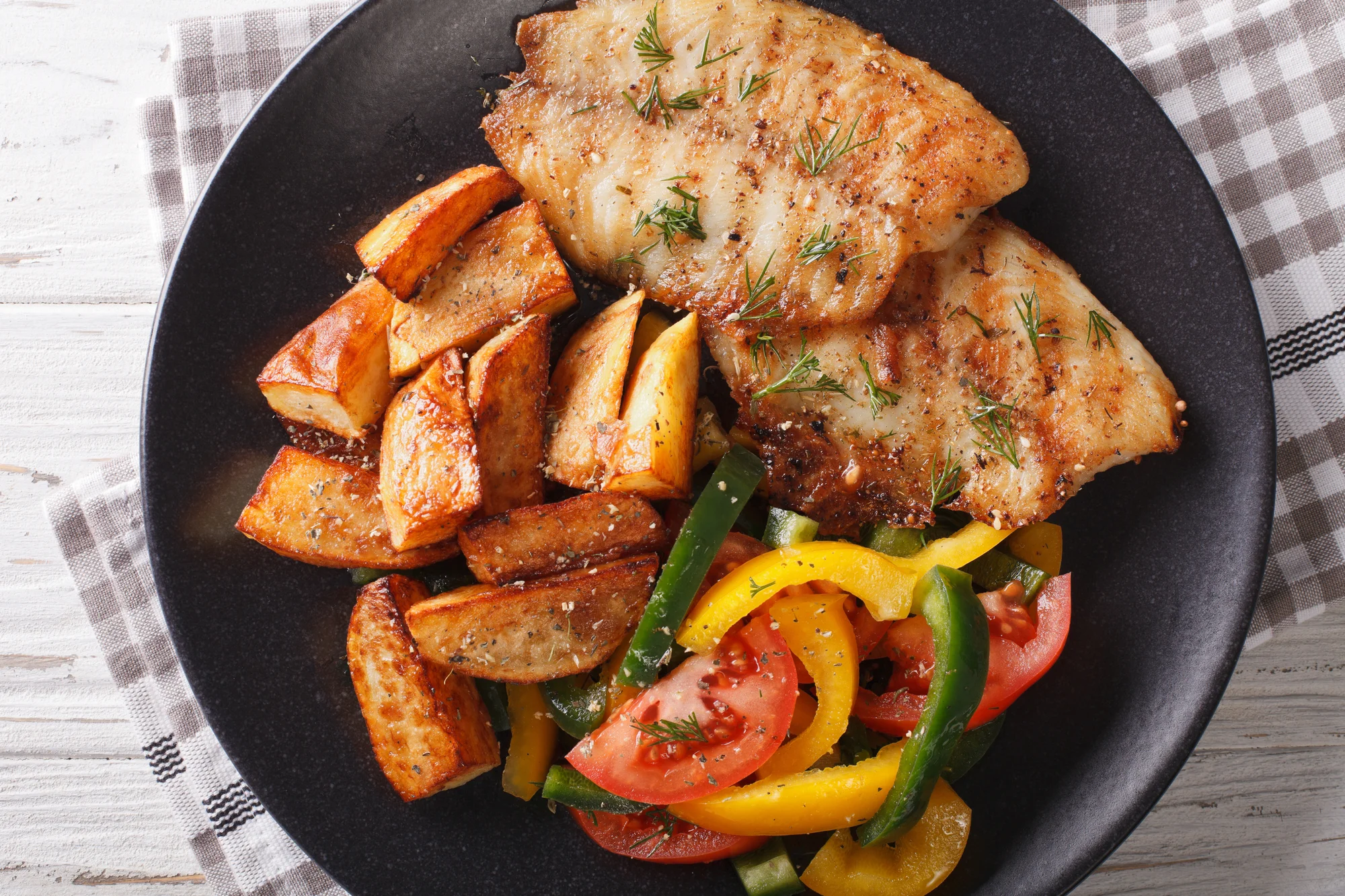 Grilled fish, potato wedges and salad